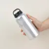 Mano sujetando una botella de agua reutilizable de aluminio reciclado