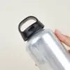 Mano sujetando una botella de agua reutilizable de aluminio reciclado