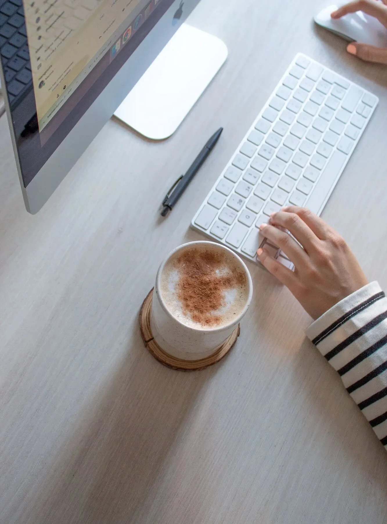 taza de ceramica y mano en mesa de trabajo con ordenador y teclado