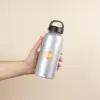 Mano sujetando una botella de aluminio personalizada con logo amarillo