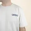 Camiseta orgánica color Beige con logro azul frontal chico