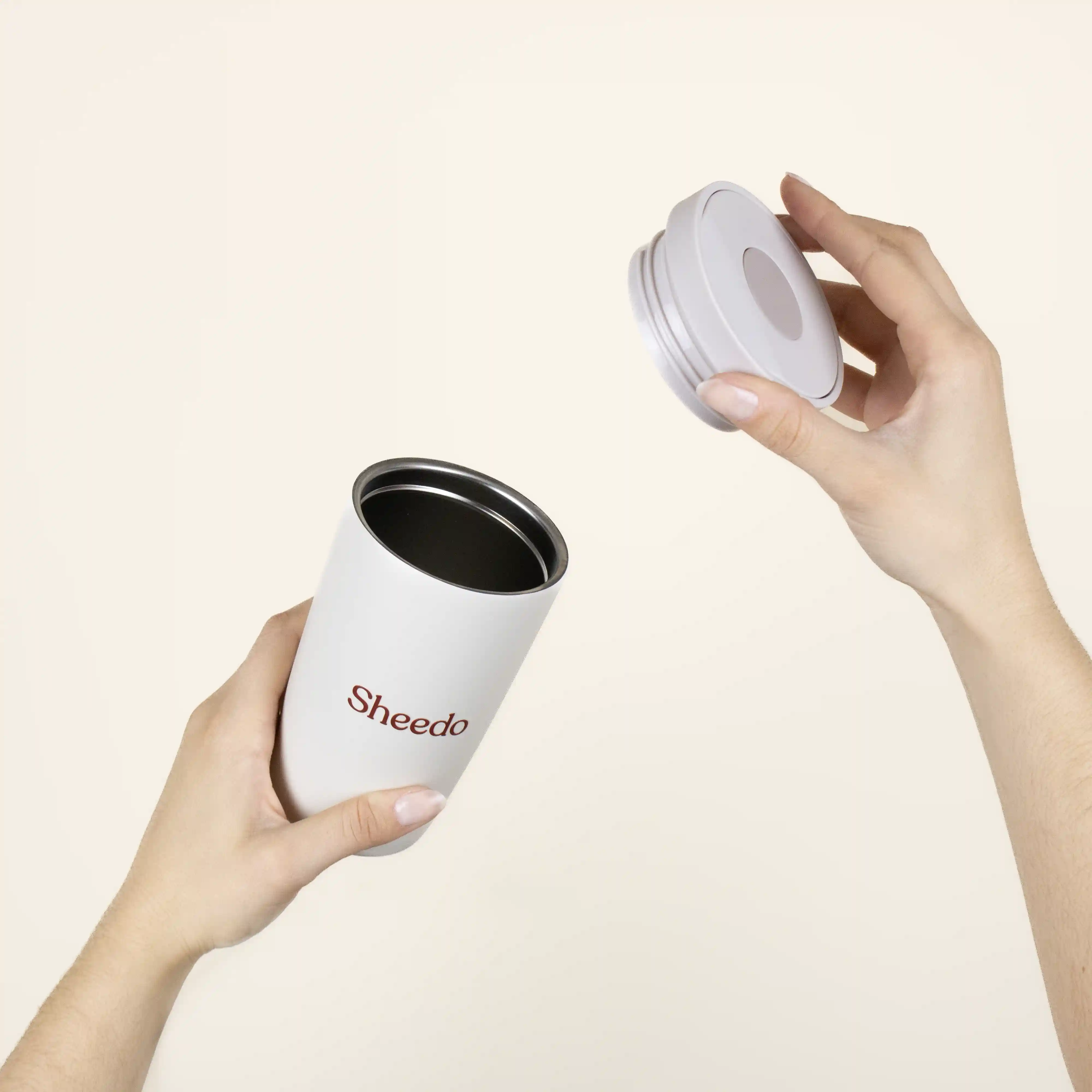 taza termo personalizada con logo abierta dos manos fondo beige