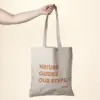 Mano sobre fondo beige sujetando una bolsa de cáñamo personalizada con logo naranja