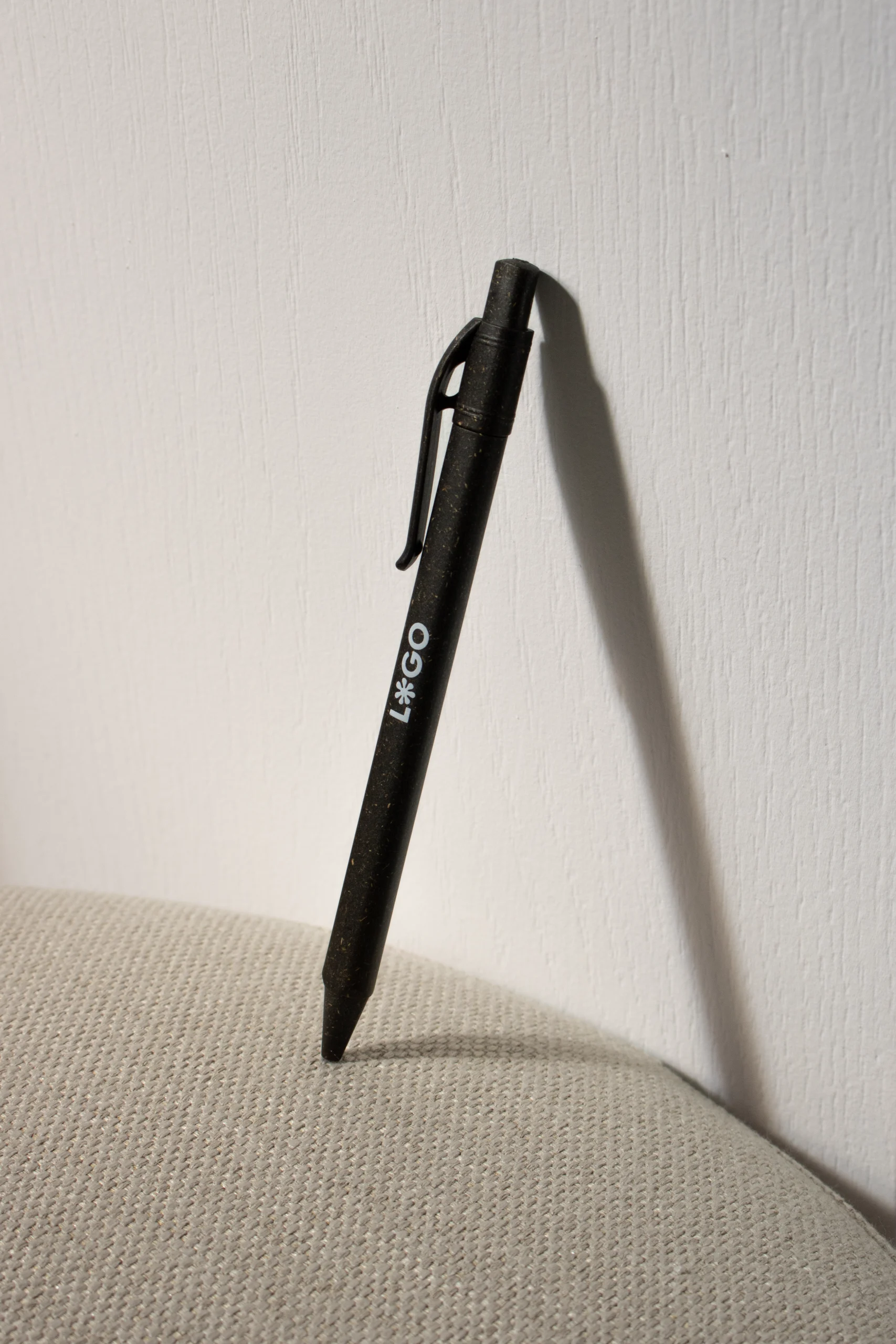 bolígrafo marrón de bioplástico de césped apoyado pared