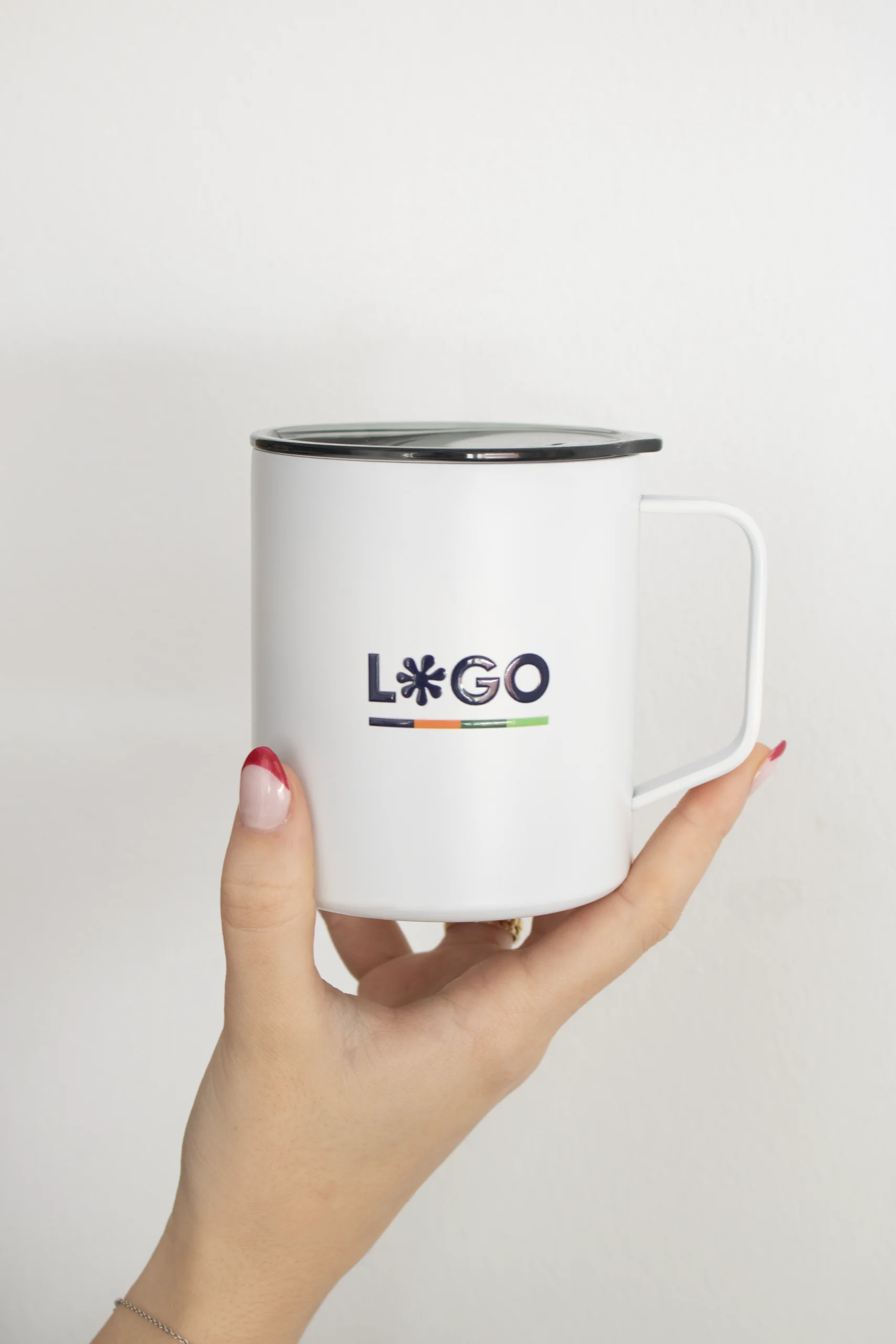 Mano de mujer sujentando un vaso térmico blanco personalizado con la palabra logo en azul