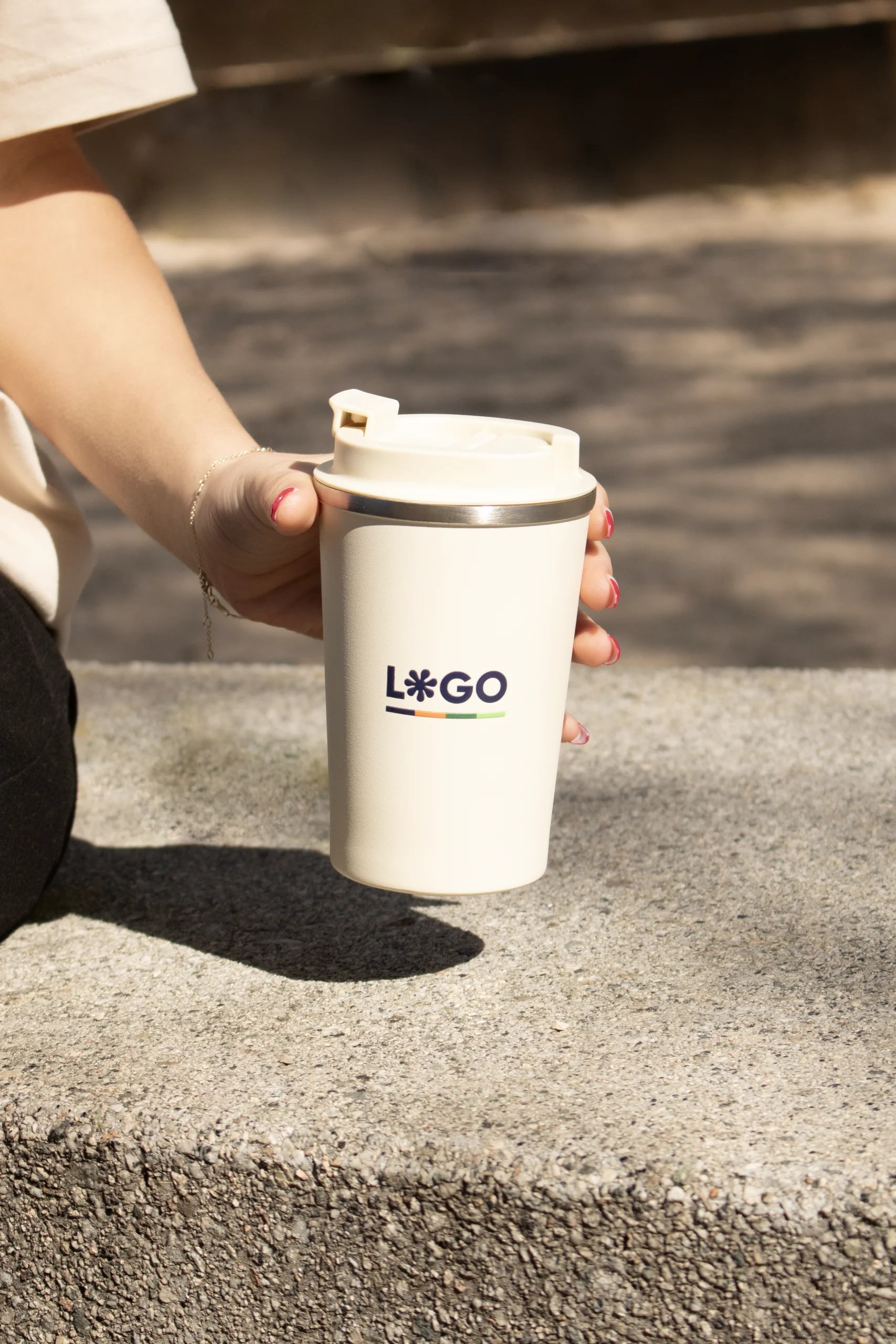 Taza take away personalizada con logo azul modelo mano fondo calle