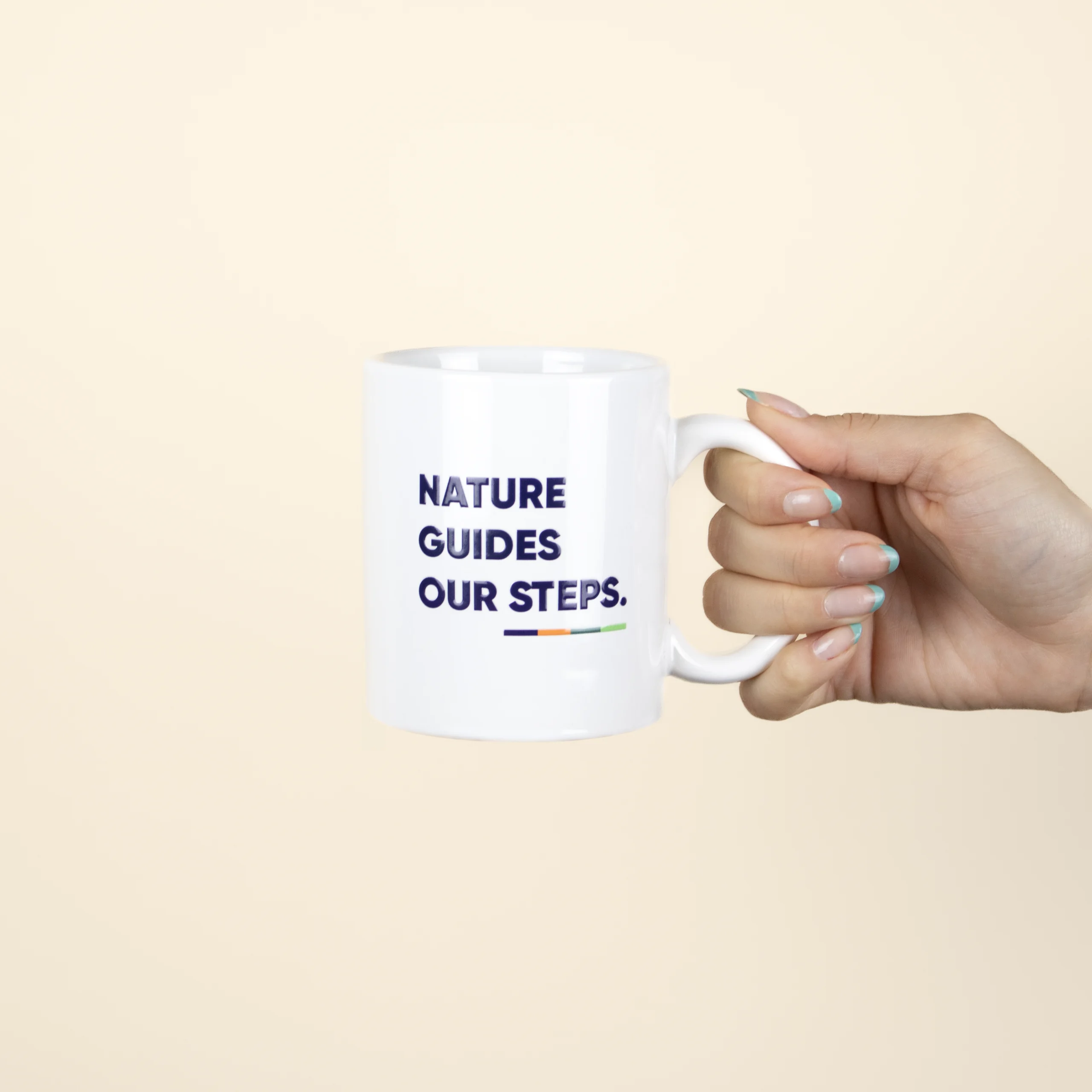 Taza Blanca personalizada con logo azul modelo mano sobre fondo beige