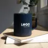 Vaso térmico con asa azul con logo blanco apoyada en cuadernos
