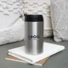 Taza termica plateada FITO Taza termica plateada tapa negra sobre cuadernos