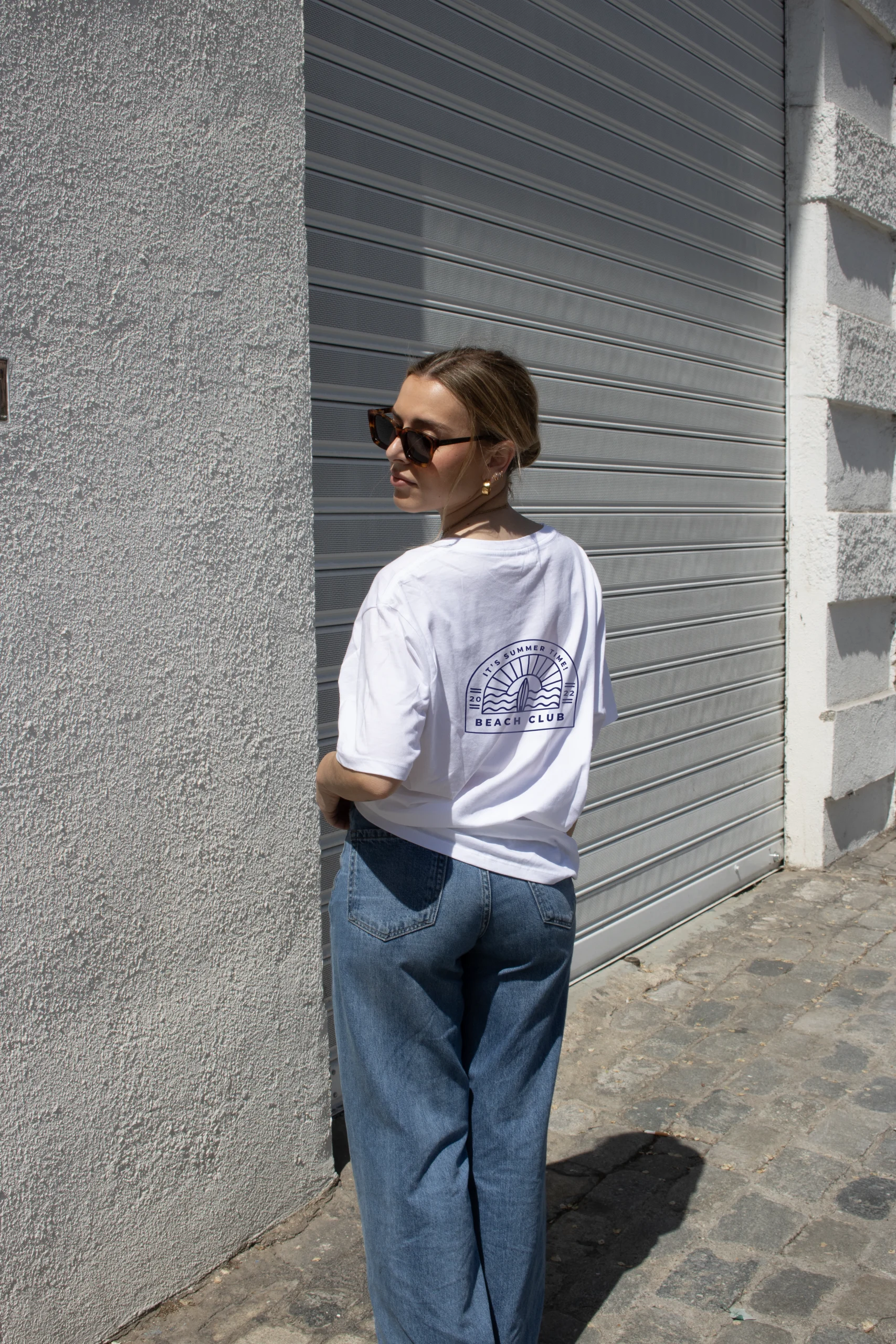 Camisetas oversize personalizadas blanca con logo espalda modelo chica con gafas en la calle