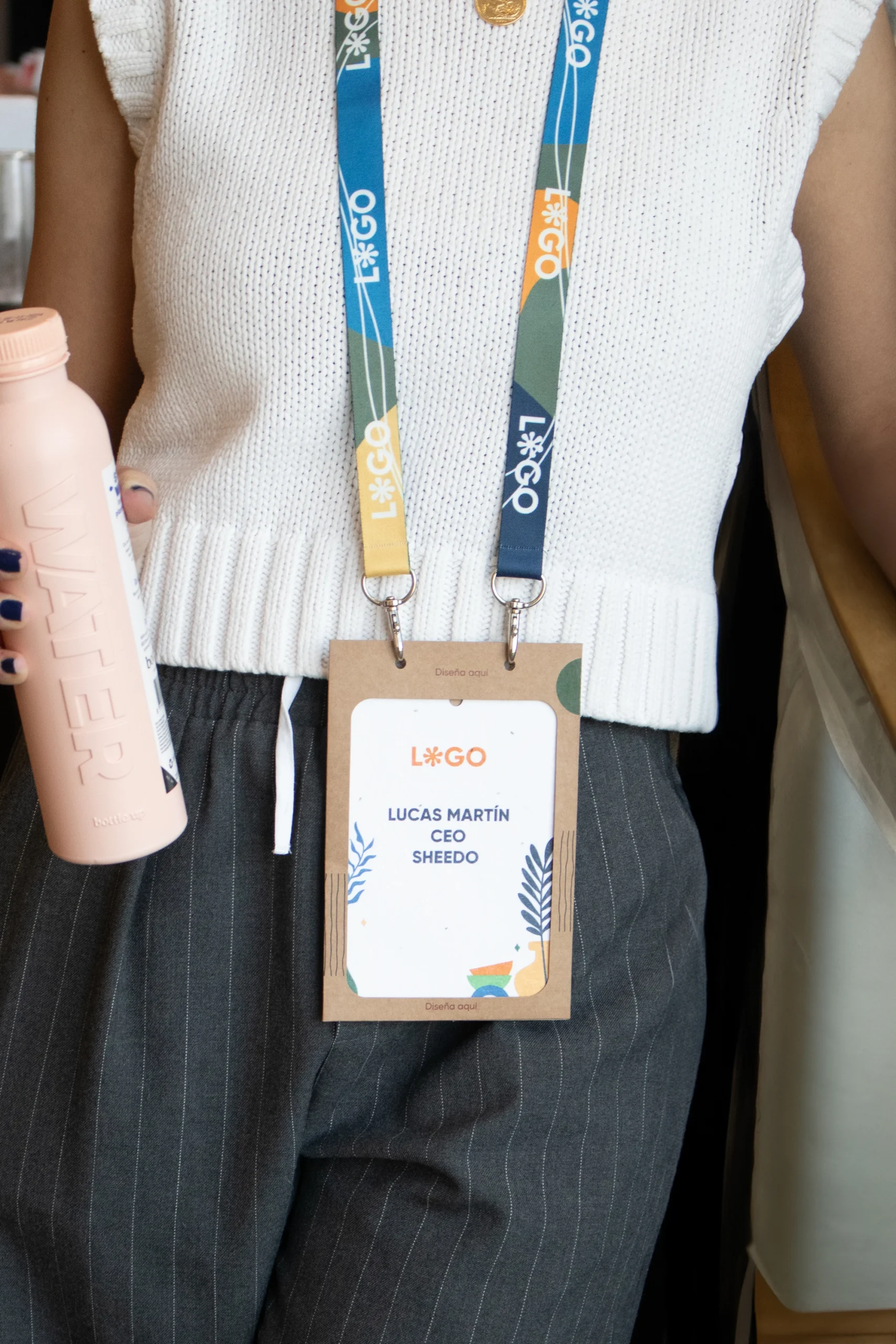 Lanyards personalizados con acreditación colgado de modelo chica con botella rosa