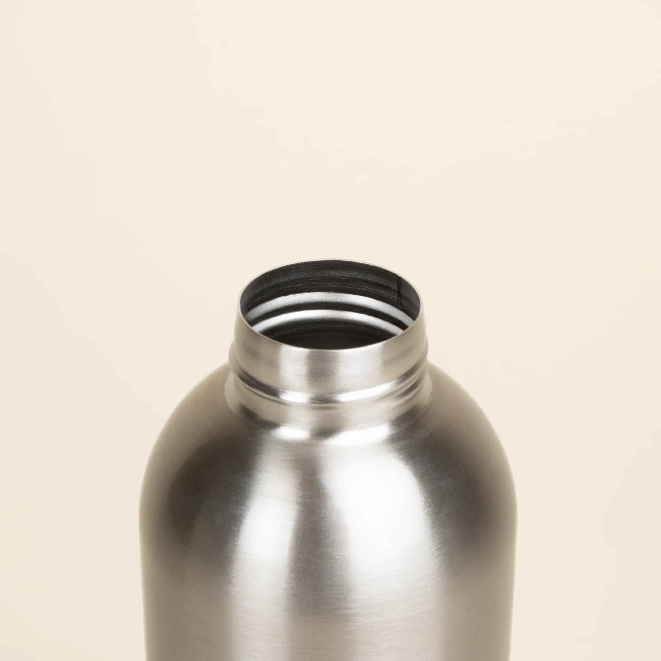 Botella acero inoxidable personalizada abierta color plateado fondo beige