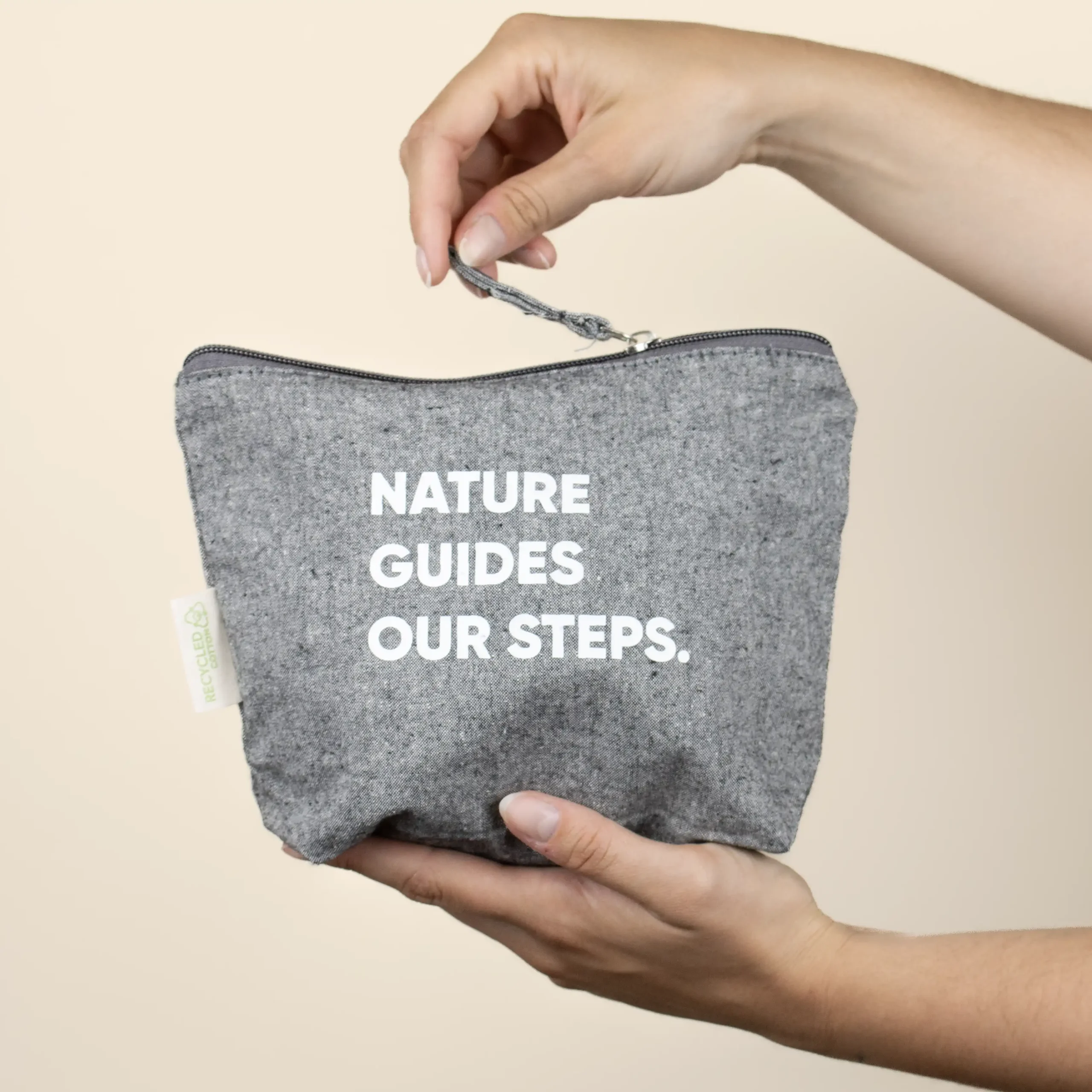 Neceser algodón ecológico COTTO Gris Mano Neceser de algodón gris personalizado con texto blanco modelo manos fondo beige