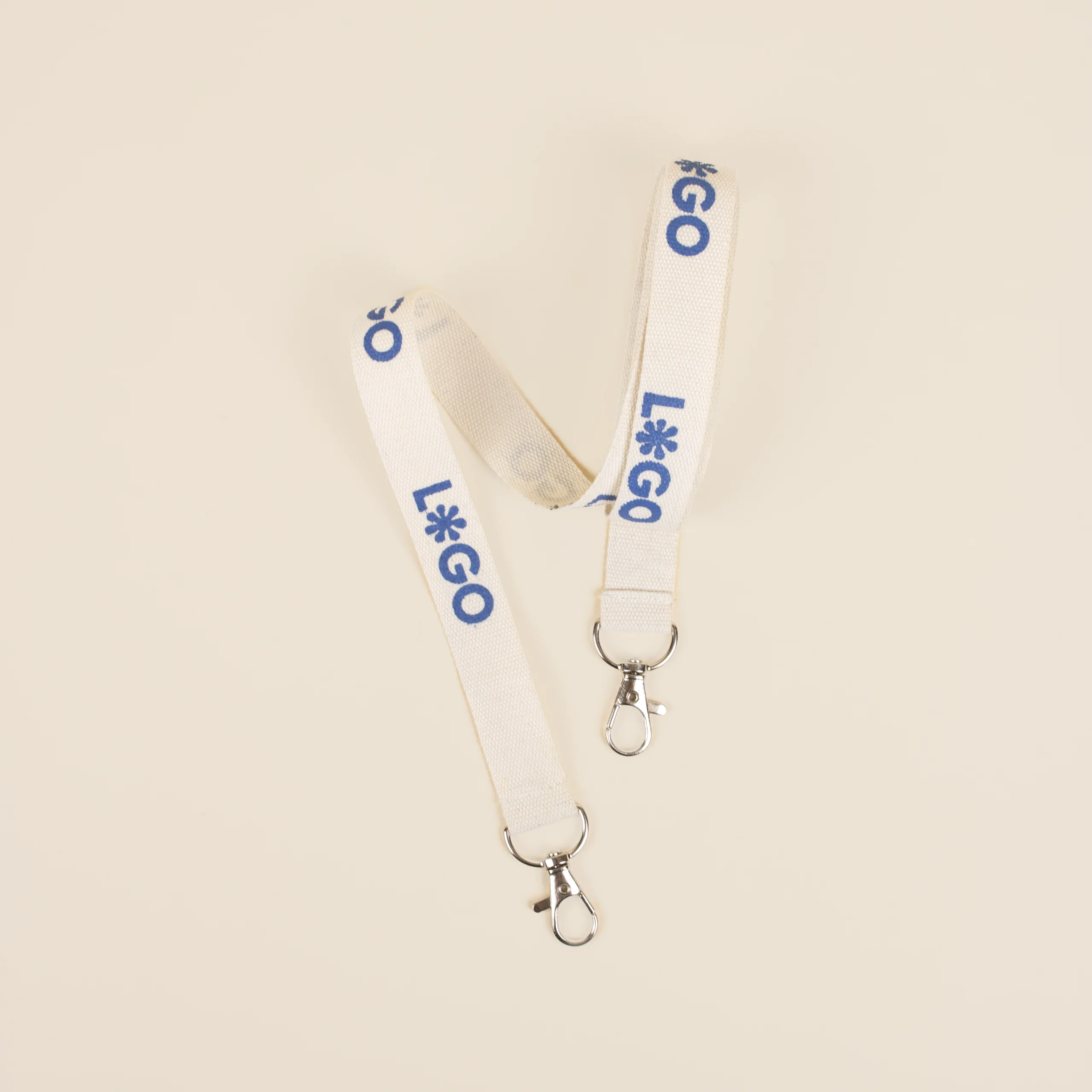 Lanyard algodón dos mosquetones logo azul fondo beige
