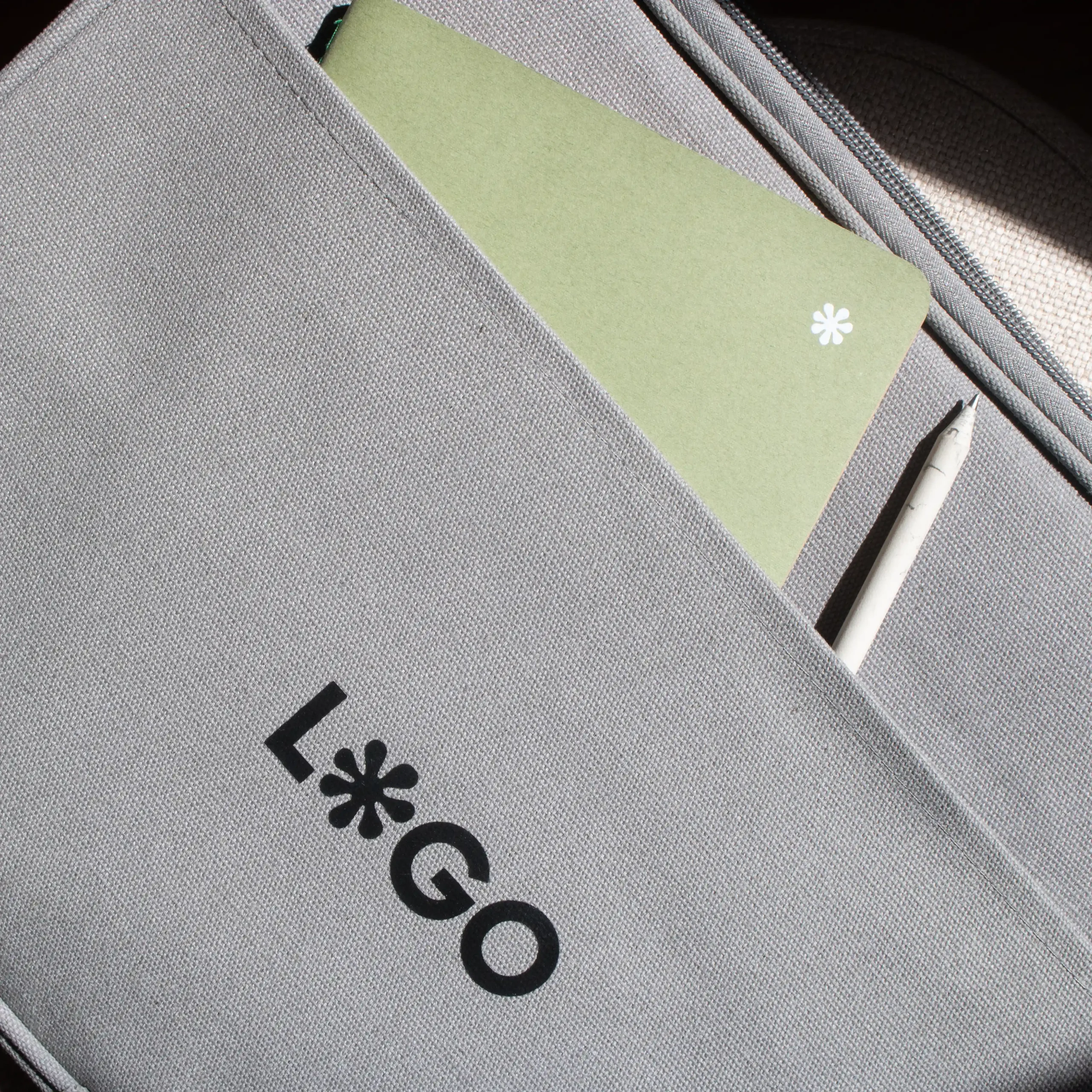 Funda portátil gris 14 pulgadas personalizada con logo negro cuaderno verde lapicero blanco