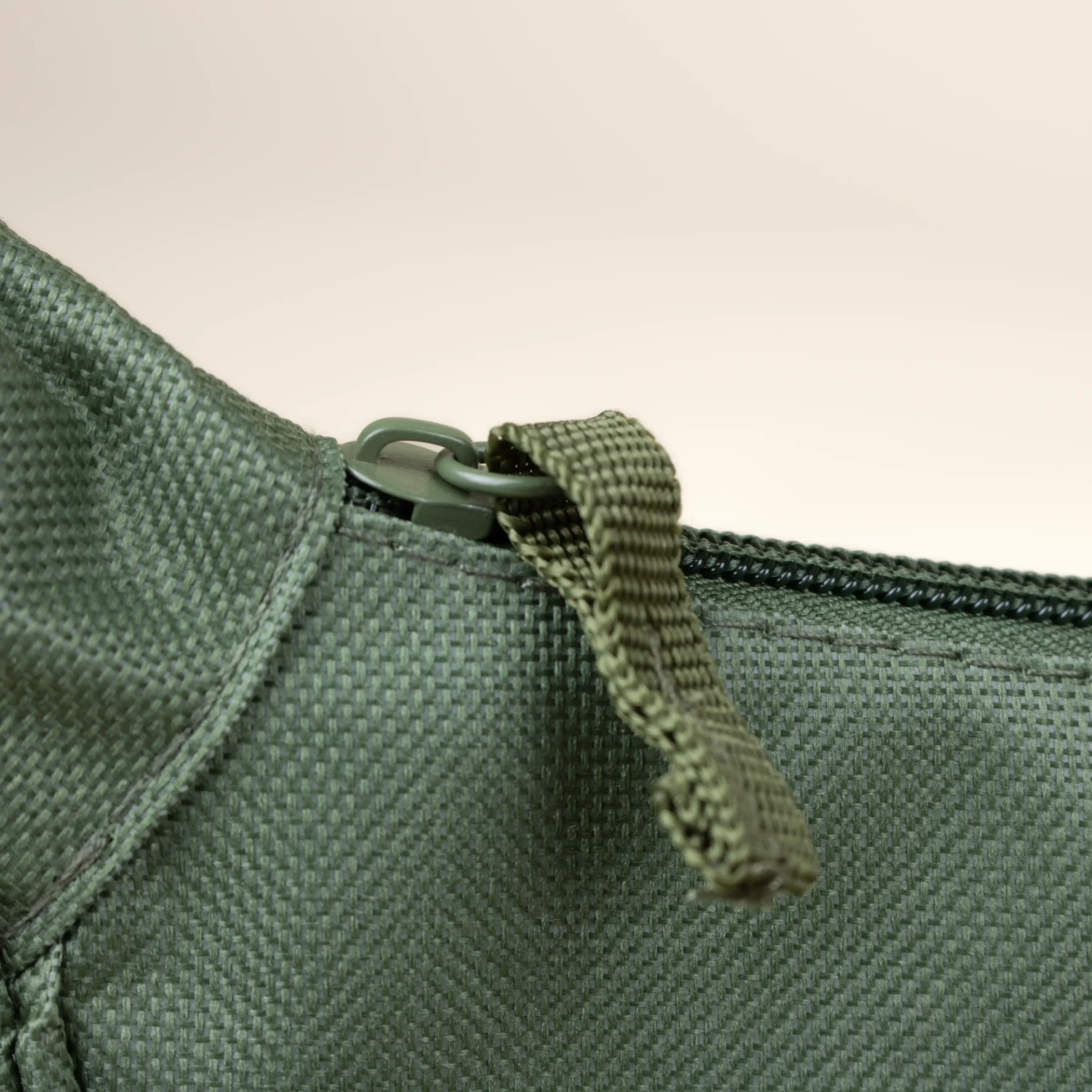 Riñonera verde detalle cremallera fondo beige