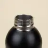 Botella térmica color negro NORMA Tapón Botella térmica color negro detalle tapón fondo beige