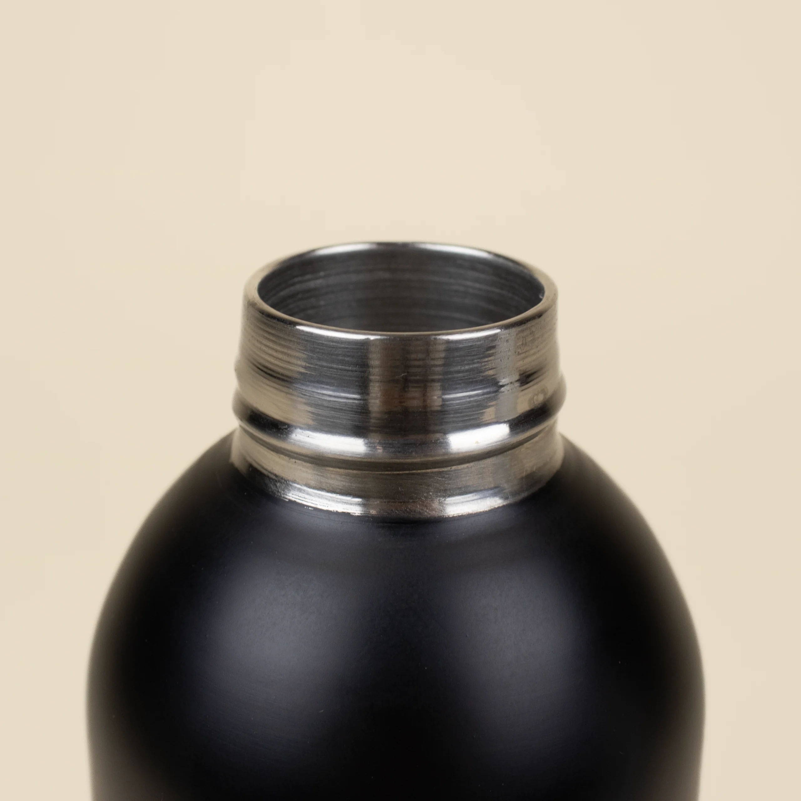 Botella térmica color negro NORMA Tapón Botella térmica color negro detalle tapón fondo beige