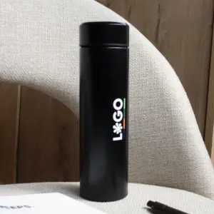 Termo acero inoxidable personalizado negro logo blanco apoyado en silla gris