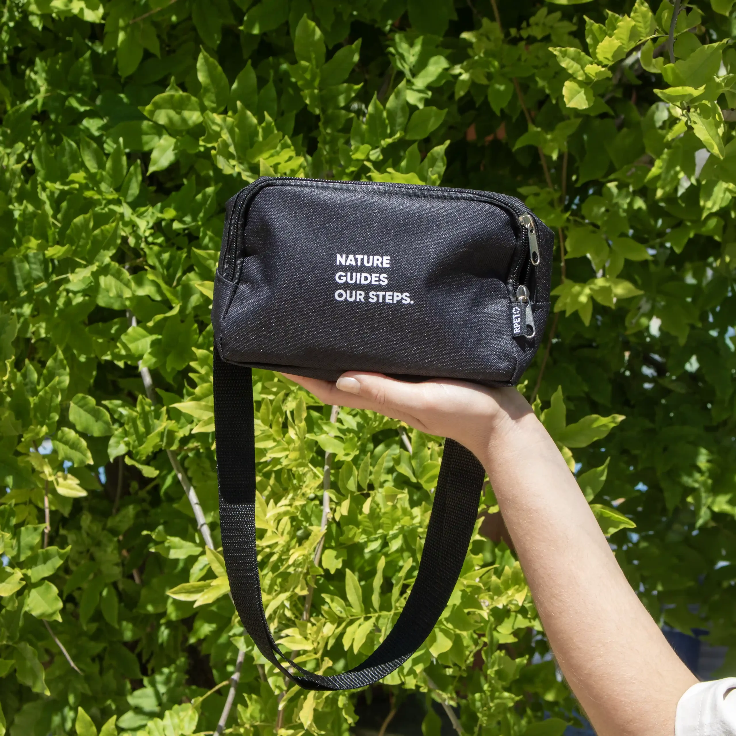 Riñonera negra rectangular PORTIA Sol Riñonera negra rectangular personalizada modelo mano fondo árboles