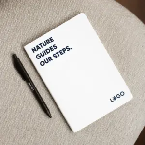 Cuaderno papel de piedra blanco personalizado con texto azul y bolígrafo