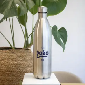 Botella térmica 850ml personalizada logo azul delante de maceta con planta