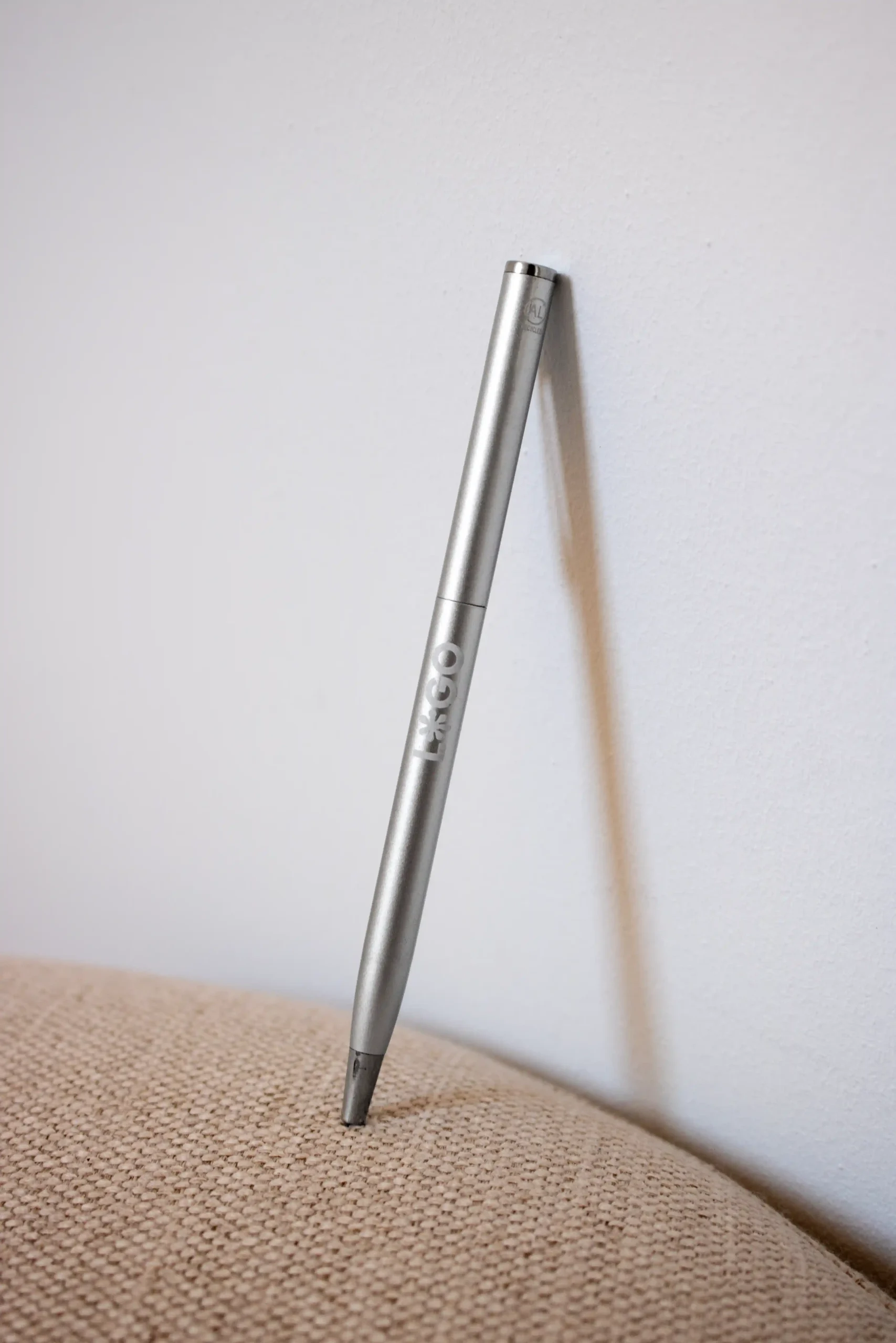 Bolígrafo de aluminio personalizado con logo apoyado en la pared