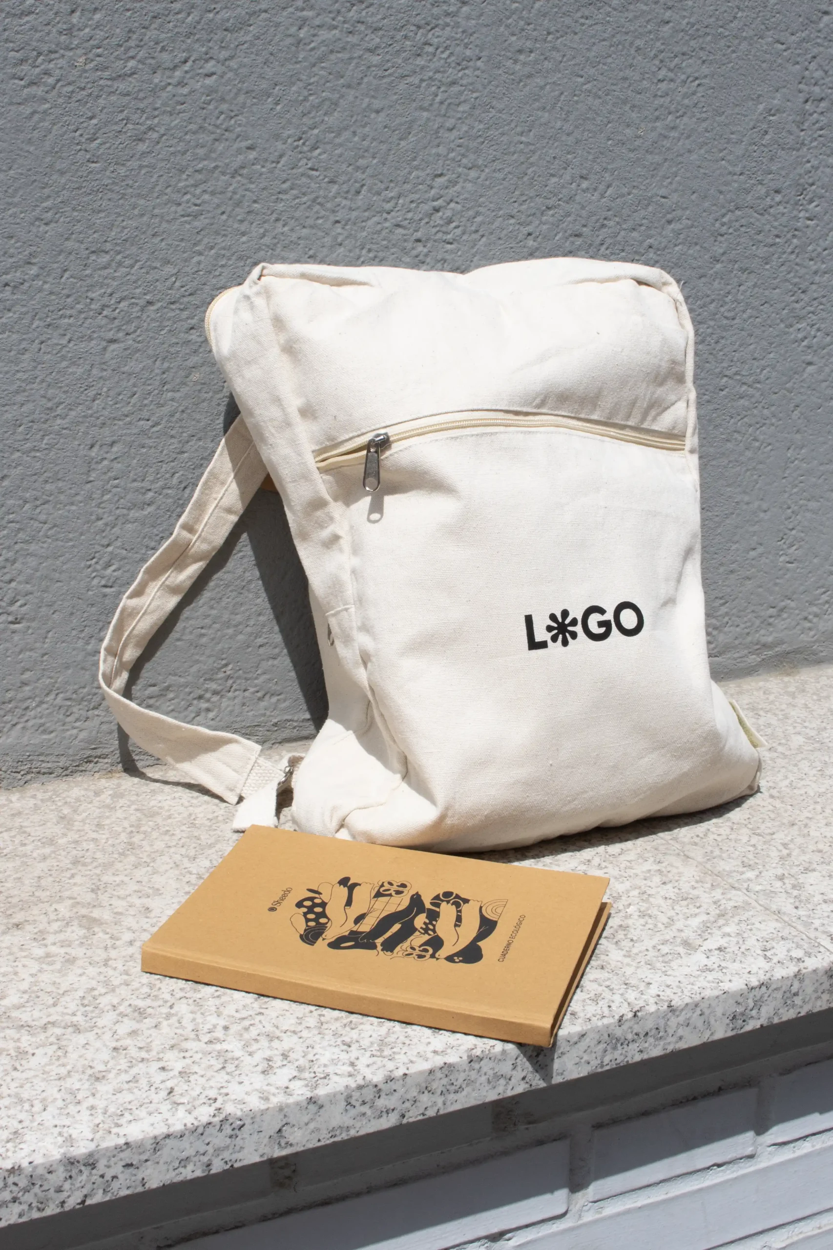 Mochila de algodón personalizada beige con logo negro con cuaderno kraft