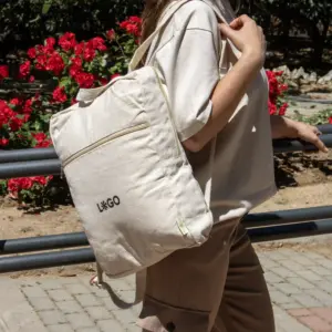 Mochila de algodón personalizada beige con logo negro modelo chica en la calle