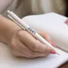 Bolígrafo trigo GLUT Beige Sol Mano escribiendo en cuaderno con bolígrafo de caña de trigo blanco personalizado con logo