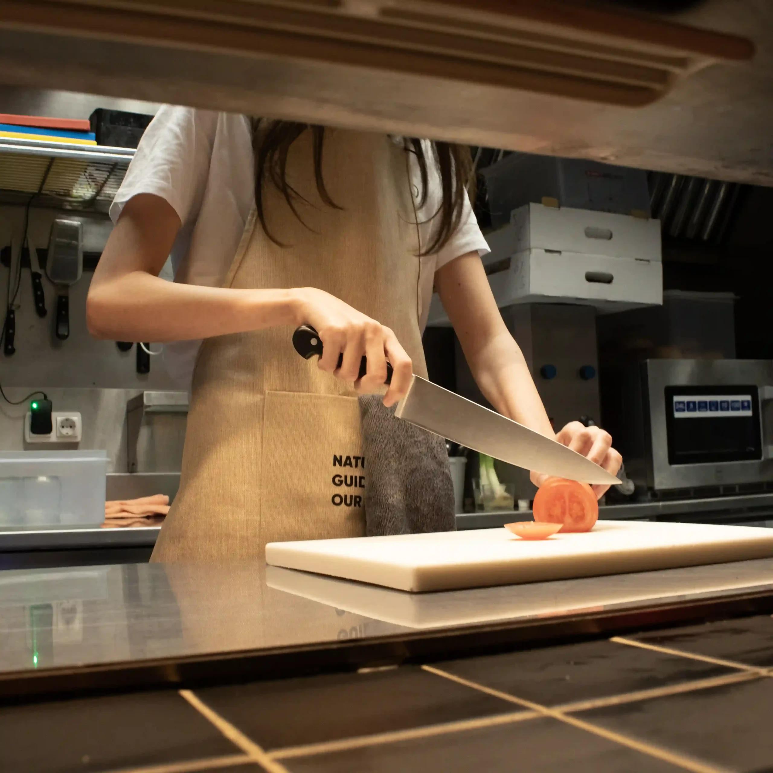 Tablier écologique modèle femme dans la cuisine d'un restaurant
