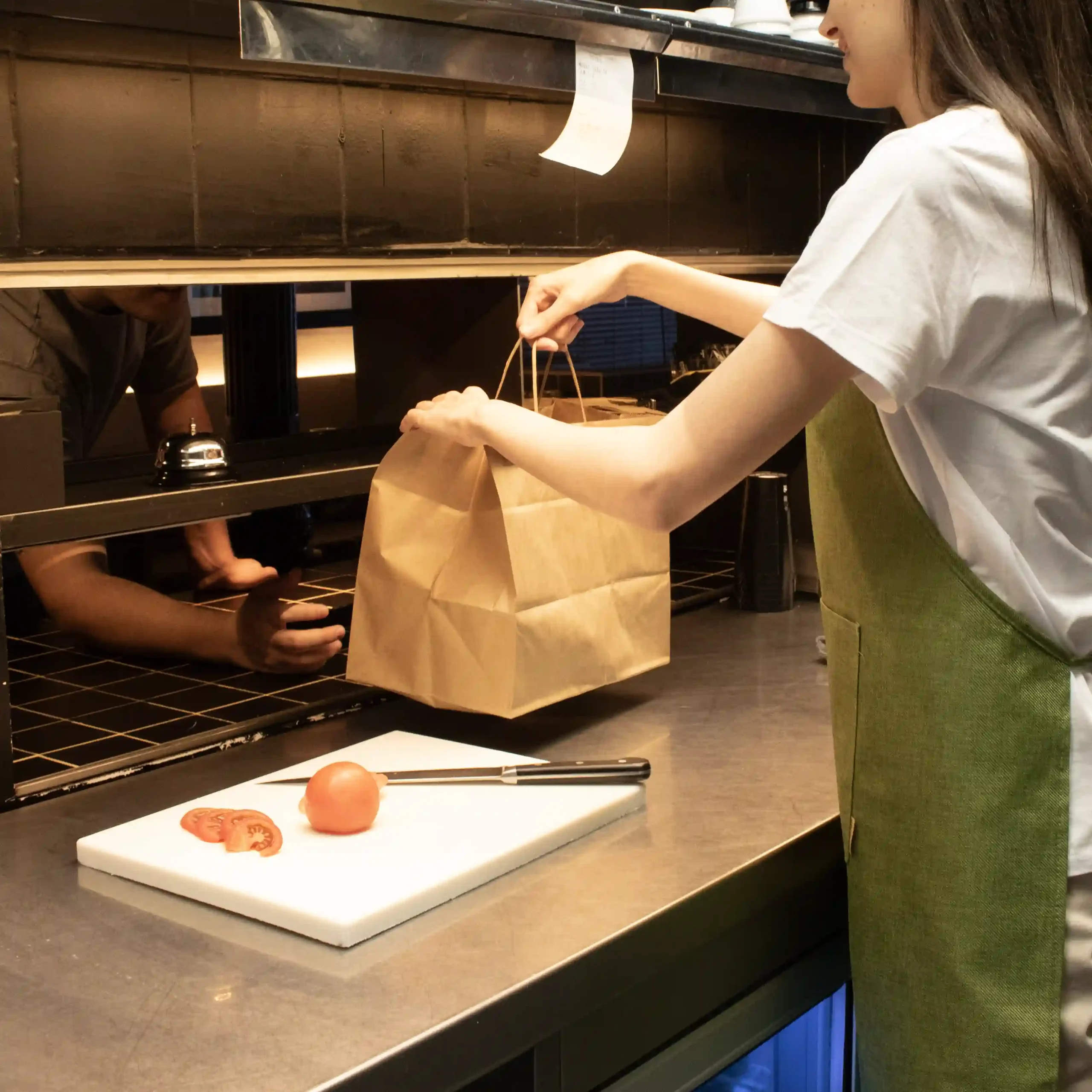 Delantal ecológico OSCAR Verde Lifestyle Delantal ecológico verde modelo chica en cocina de restaurante