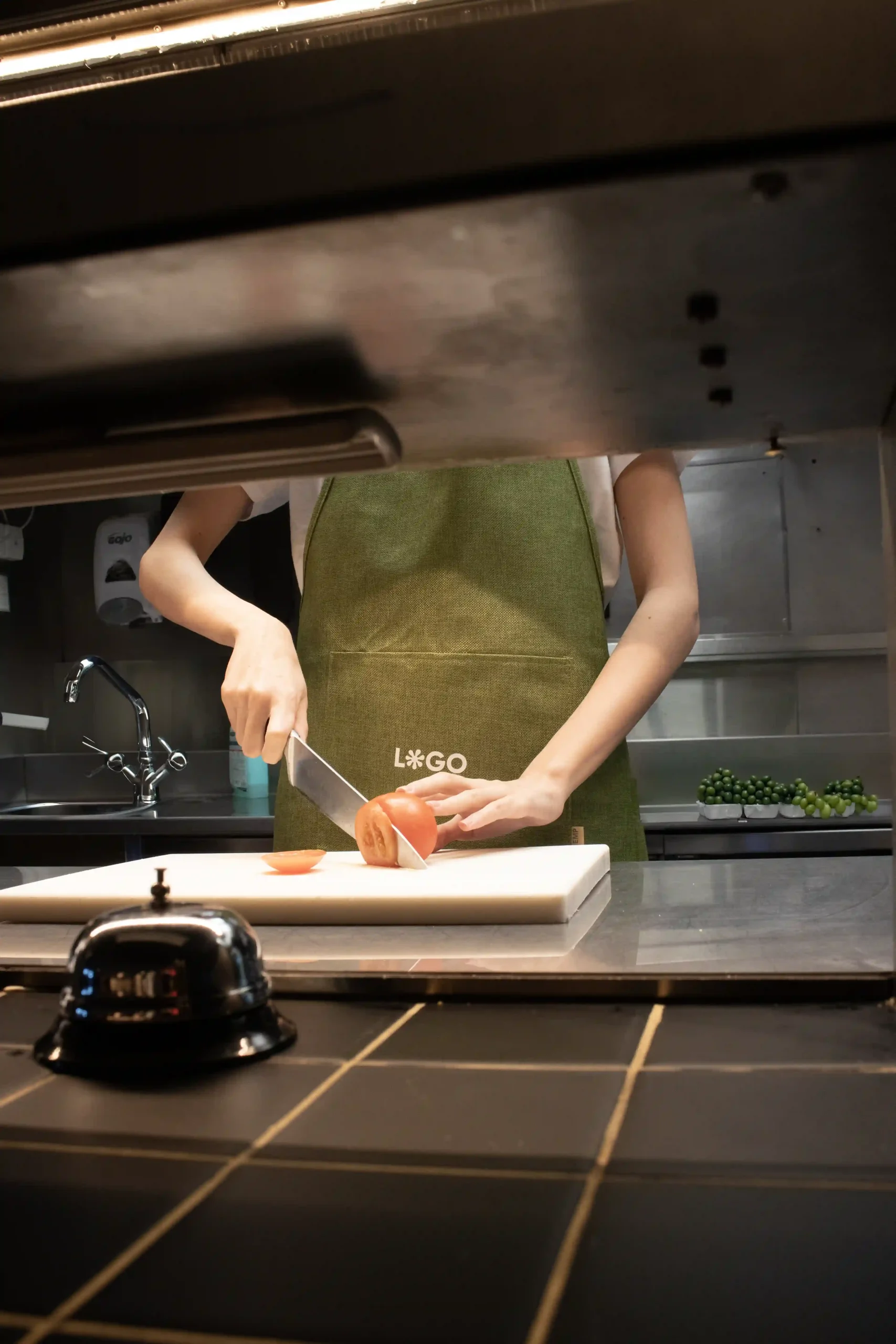 Delantal ecológico verde modelo chica en cocina de restaurante