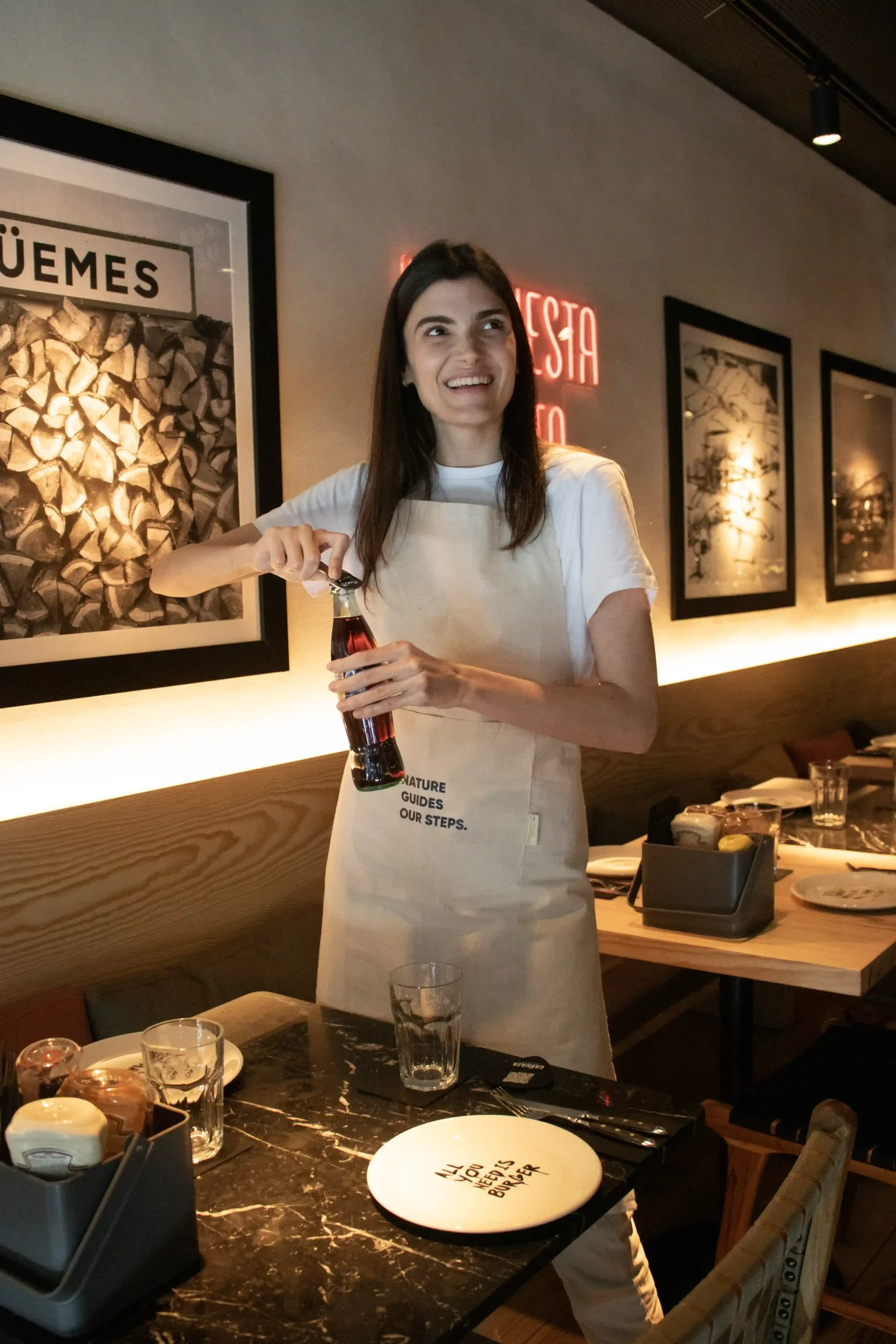 Delantal algodón personalizado color natural modelo camarera abriendo refresco