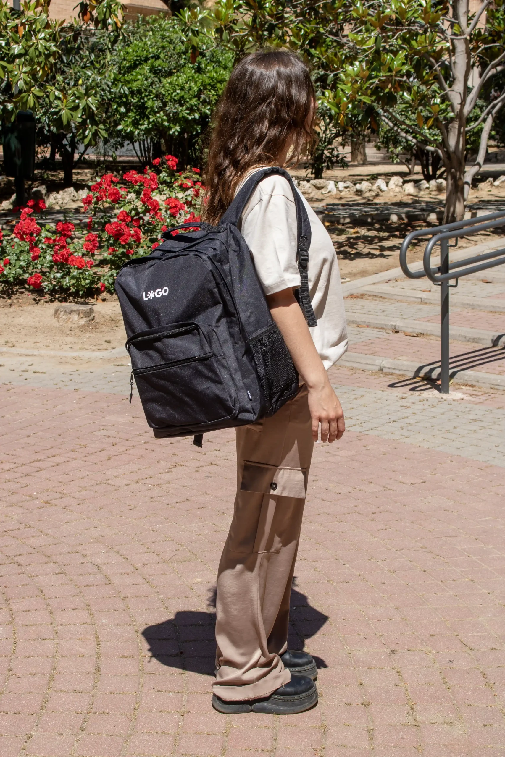 Sac à dos professionnel noir personnalisé avec logo blanc modèle fille dans la rue