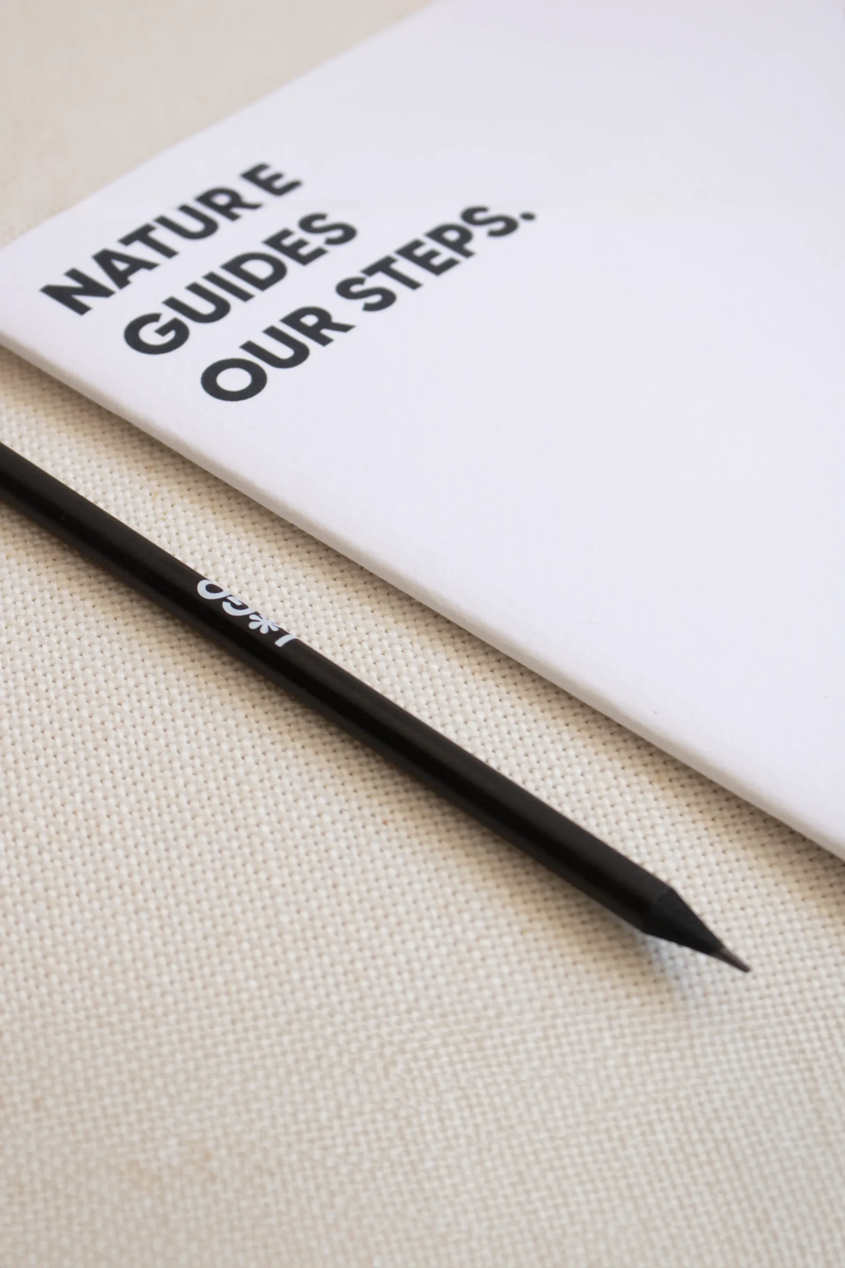 Custom black wooden pencil with white logo and white notebook
