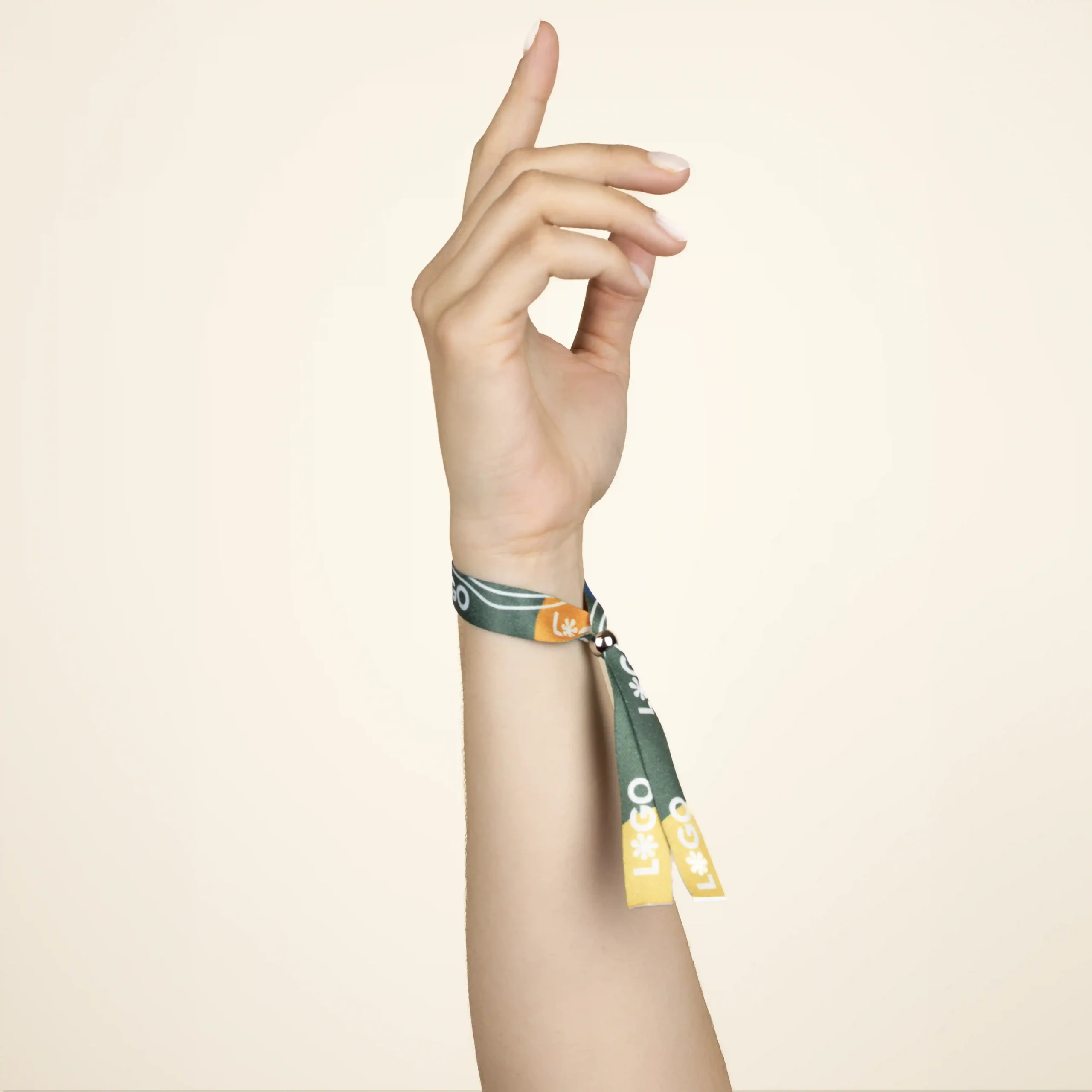 Mano sobre fondo beige llevando una pulsera reciclada en rPET personalizada con logo a todo color