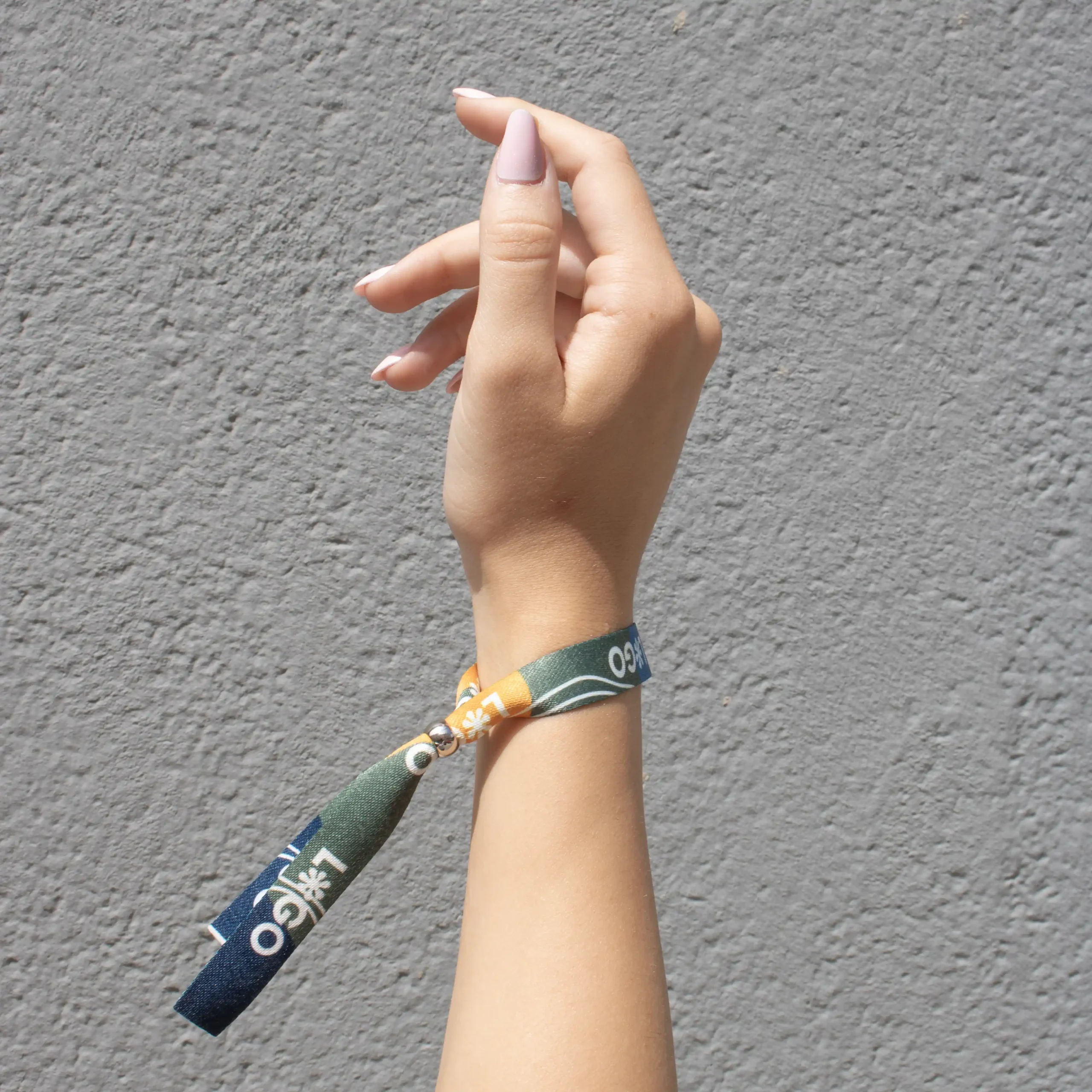 Mano llevando una pulsera reciclada en rPET personalizada con logo a todo color