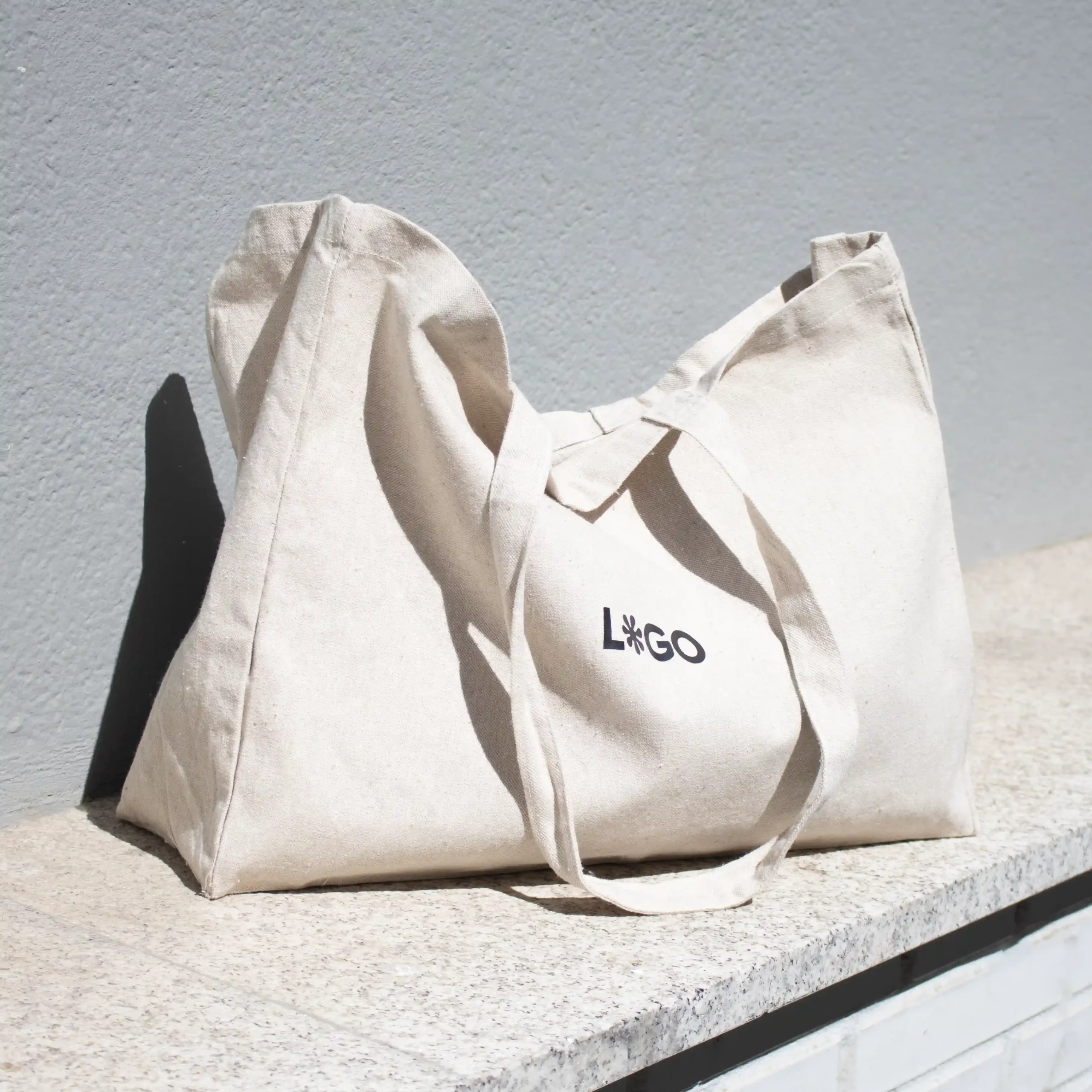 bolsa de algodón reciclado personalizada con logo con fondo pared gris