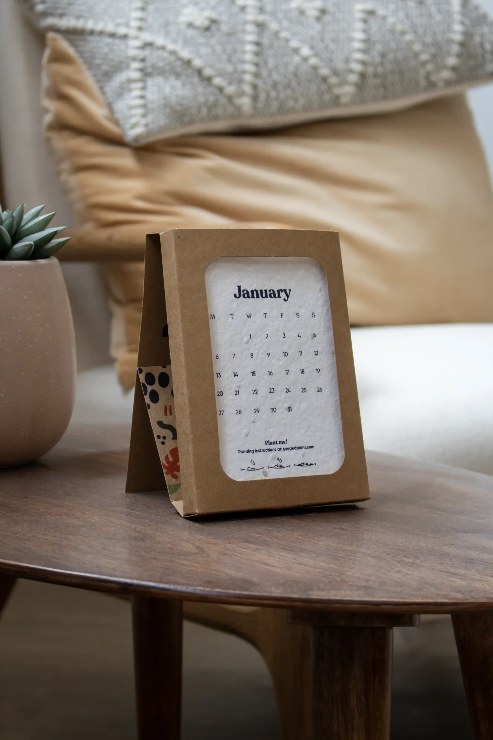 Calendario de semillas en estuche kraft personalizado colocado sobre una mesa madera