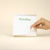 Calendario plantable de mesa TRIGA Mano pasando la hoja de octubre de una calendario plantable de mesa