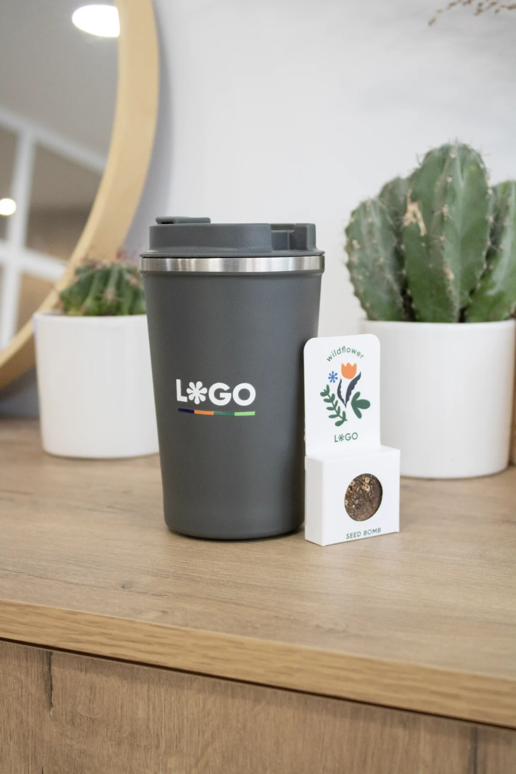 Taza térmica gris personalizada con logo blanco con dos cactus y una bomba de semillas