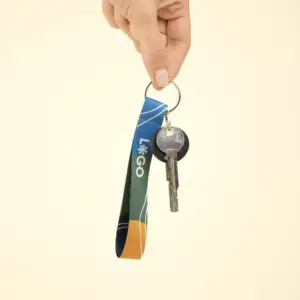 mano cogiendo un llavero ecológico personalizado con logo y unas llaves