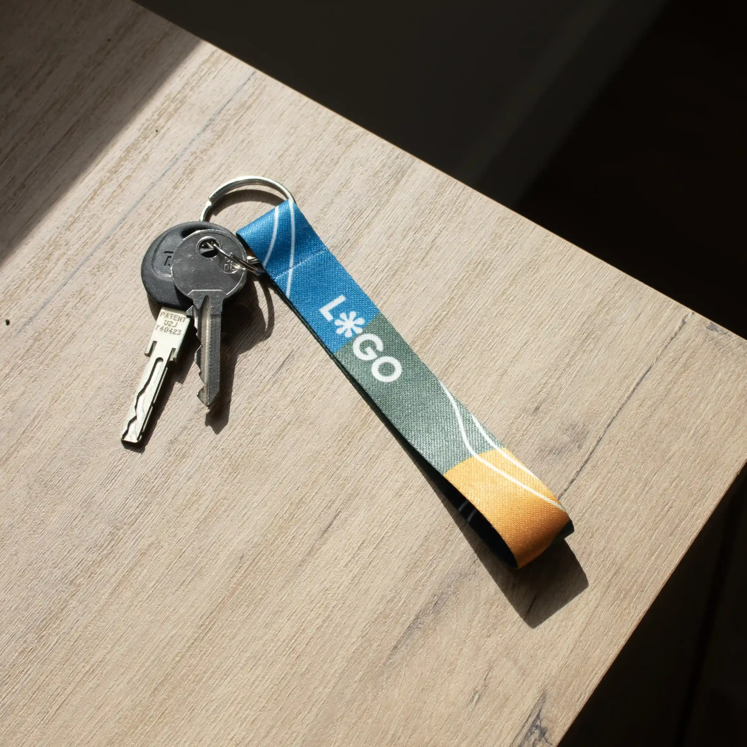 llaves con llavero ecológico personalizado con logo sobre una mesa de madera