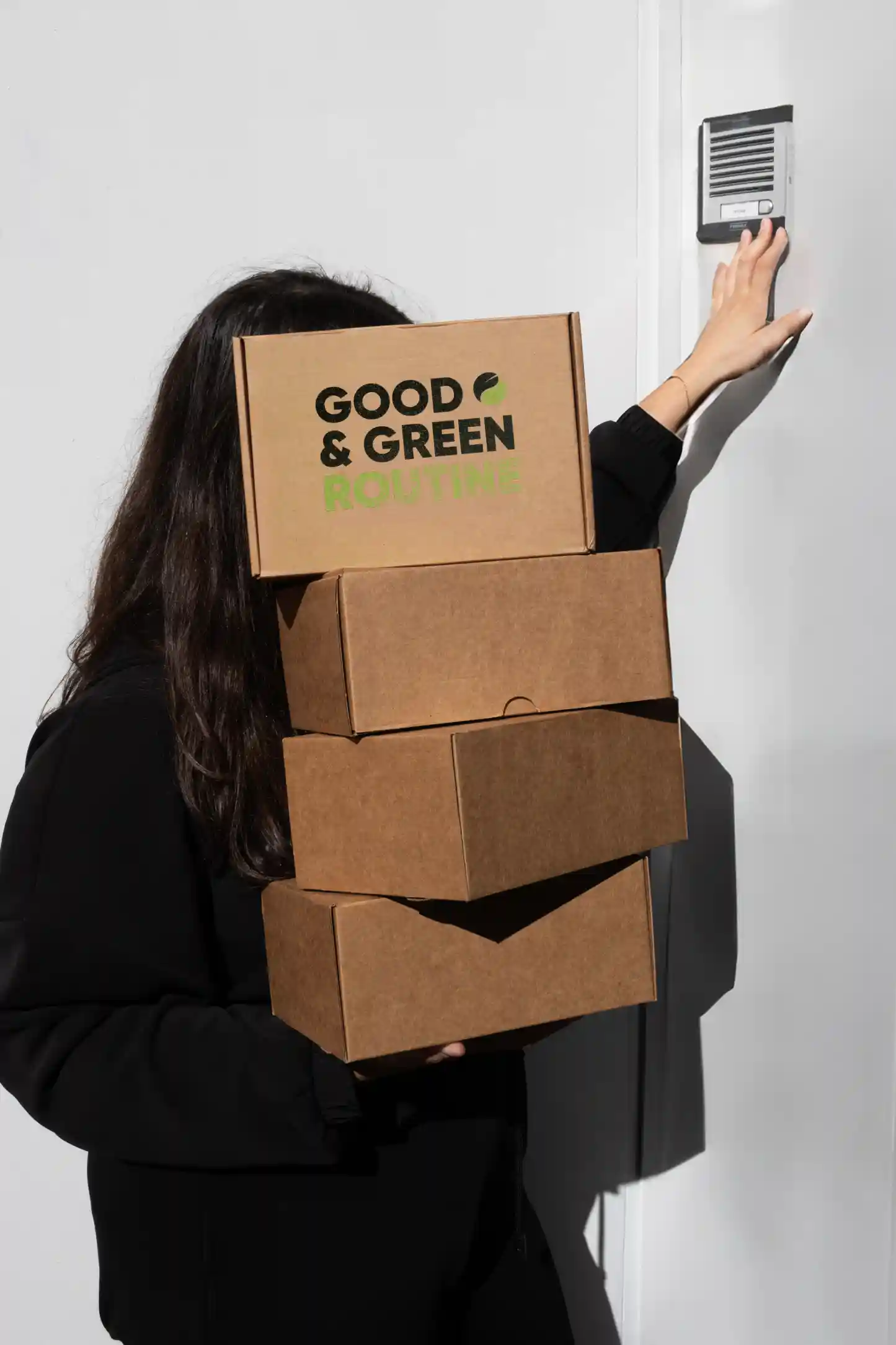 Chica cargando cajas de cartón personalizadas para welcome packs de empresa