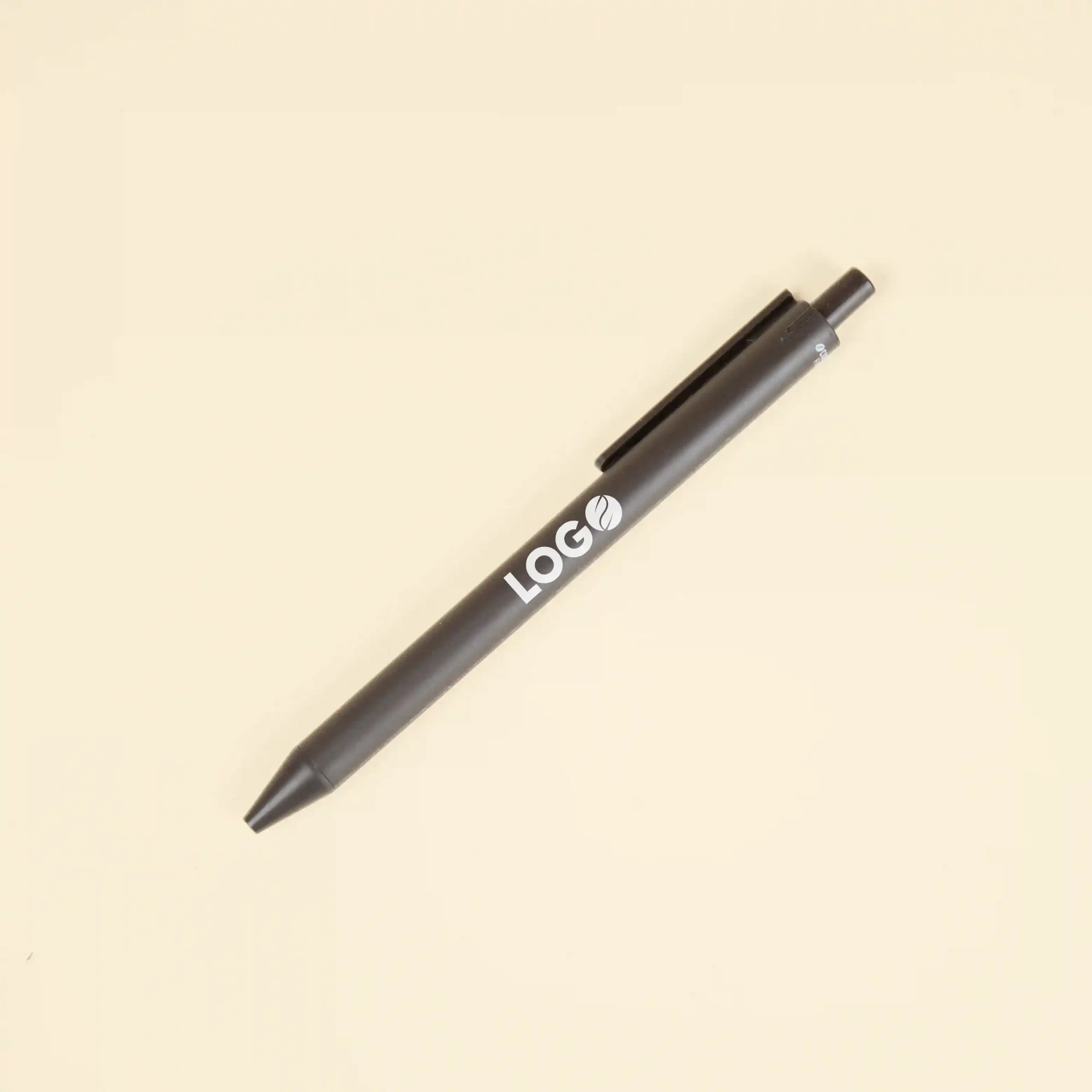 Bolígrafo marrón con la palabra logo en blanco impreso sobre fondo beige