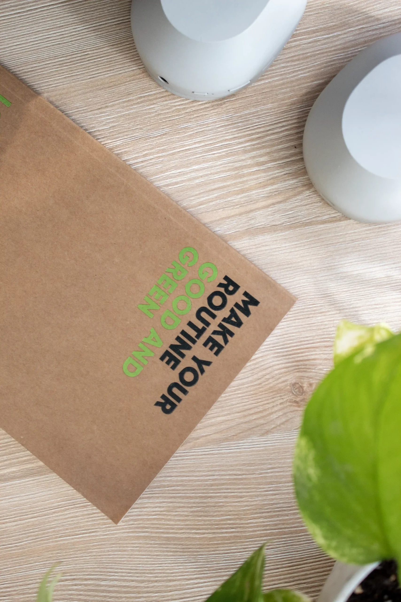 Cuaderno kraft personalizado sobre una mesa de madera junto a una planta
