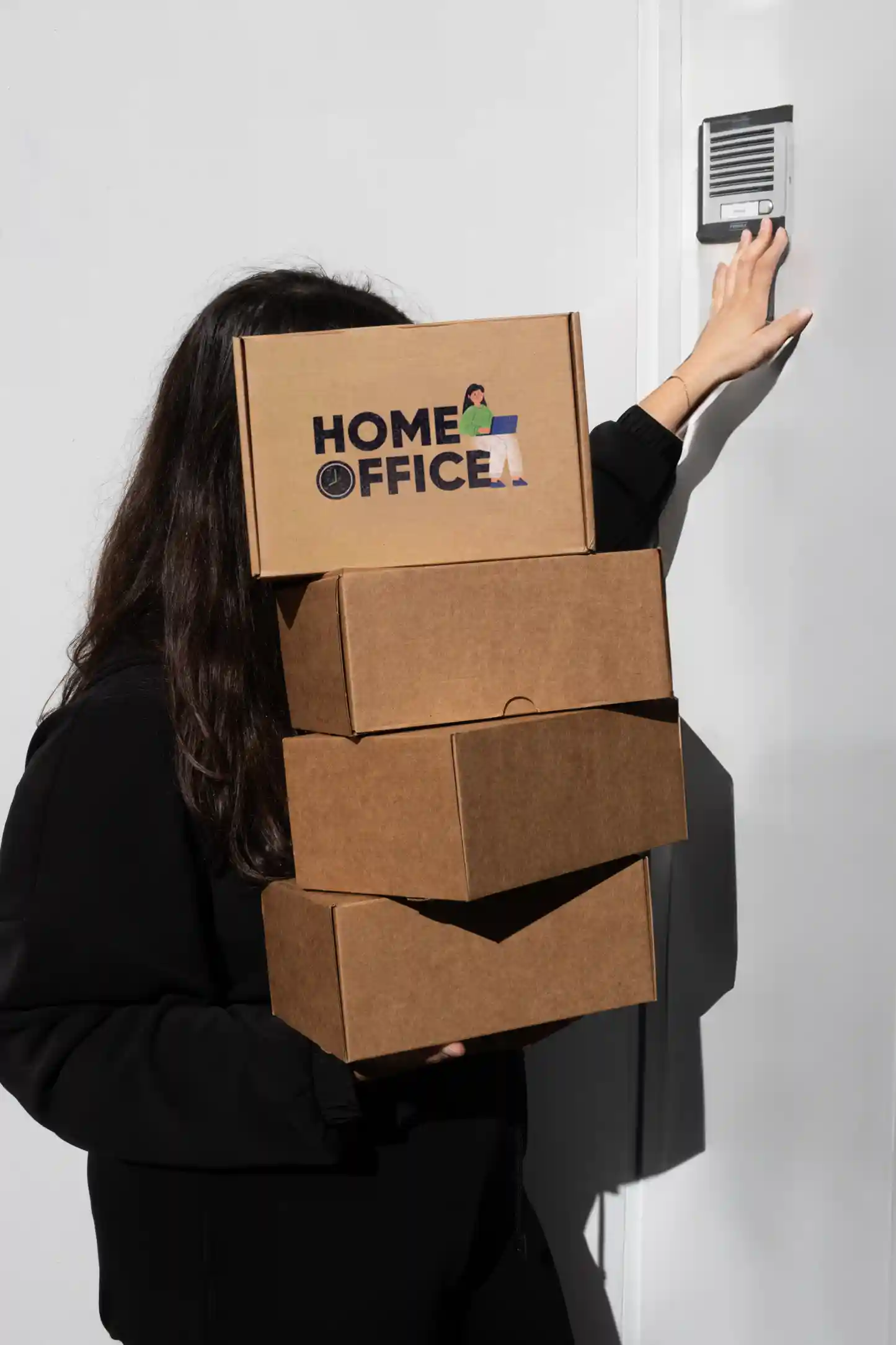 Chica cargando cajas de cartón personalizadas para welcome packs de empresa