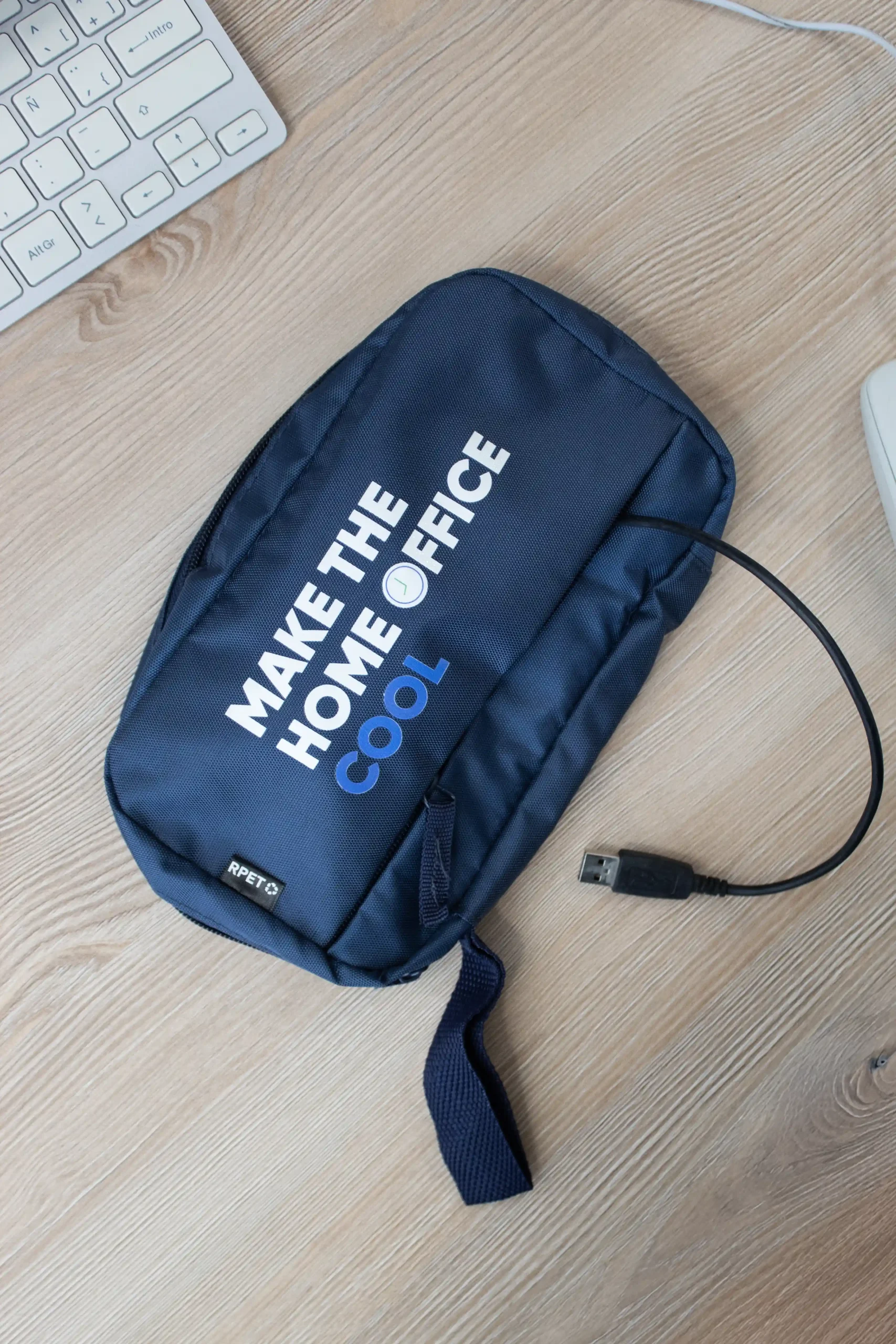 Estuche azul organizador de cables personalizado sobre una mesa de madera