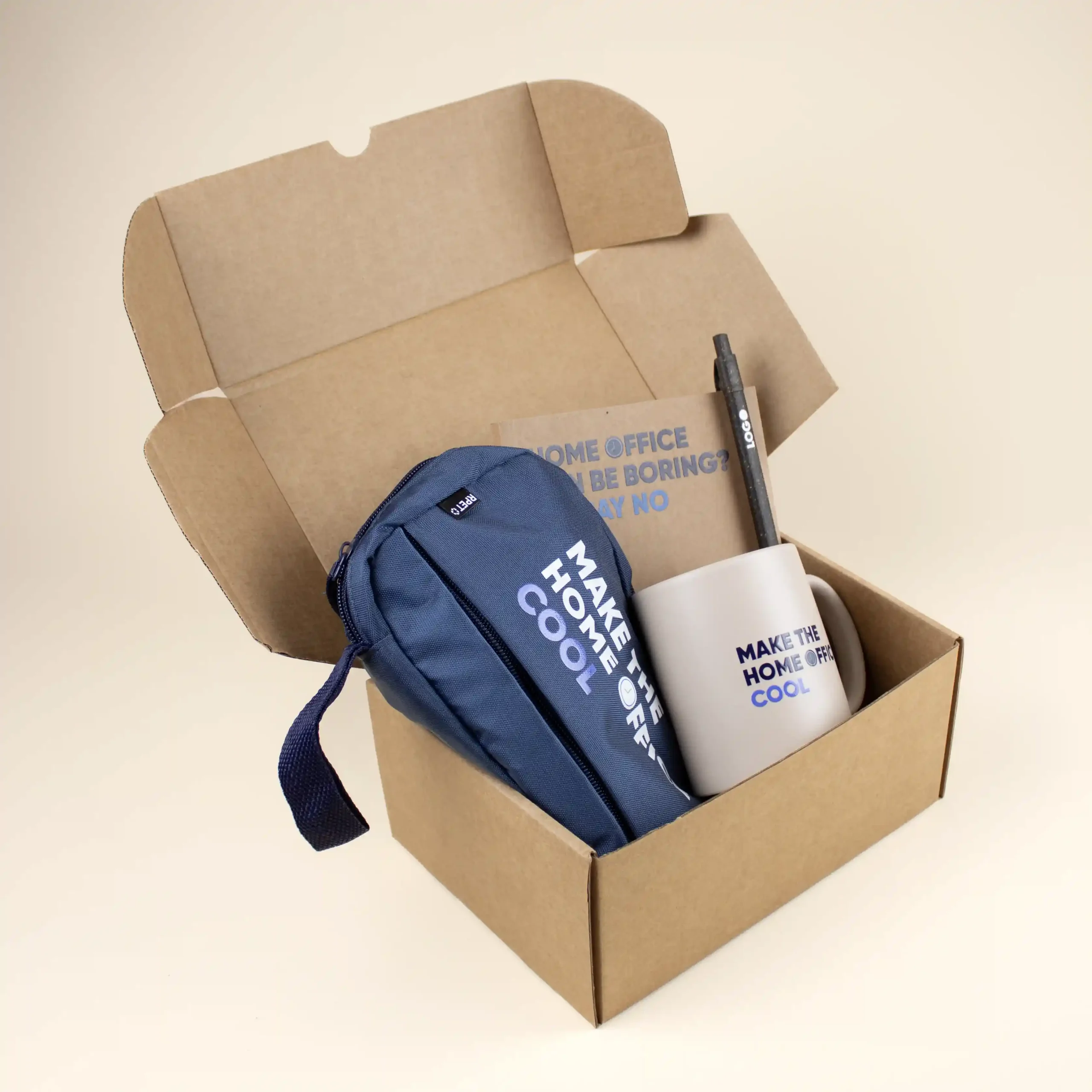 Caja de cartón abierta con un estuche azul, una taza beige, un cuaderno kraft y un bolígrafo marrón personalizados con logo